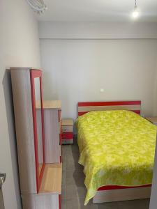 ein Schlafzimmer mit einem Bett mit einer gelben Decke darauf in der Unterkunft Airport View Apartments in Artemida