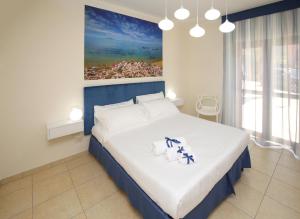 1 dormitorio con 1 cama grande y una pintura en la pared en Swimming Pool and Relax Apartment, en Castelsardo