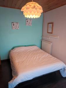 a bedroom with a bed with a blue wall at Maison individuelle 5 personnes in Villar-Saint-Pancrace