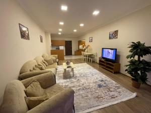 uma sala de estar com sofás e uma televisão de ecrã plano em Azure apart em Baku