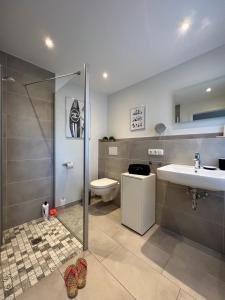 a bathroom with a shower and a sink and a toilet at Ferienwohnung Dünenbutze in Büsum