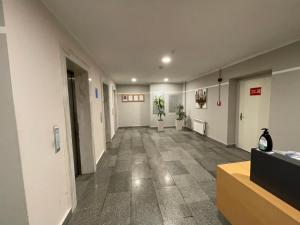 um corredor vazio num edifício de escritórios com plantas em Azure apart em Baku