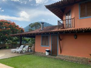 a house with a deck and chairs on it at Linda casa em Itaipava in Petrópolis