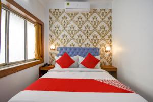 a bedroom with a large bed with red pillows at OYO Diamond Plaza Near Acropolis Mall in Jādabpur