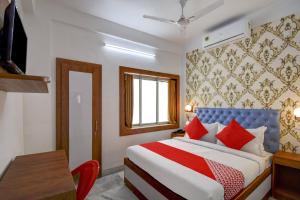 a bedroom with a bed and a desk and a window at OYO Diamond Plaza Near Acropolis Mall in Jādabpur