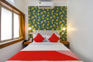 a bedroom with a large bed with red pillows at OYO Diamond Plaza Near Acropolis Mall in Jādabpur