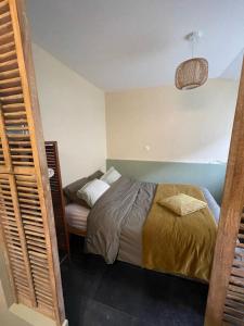 a small bedroom with a bed and a lamp at Le clos de Marissel in Beauvais