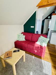 uma sala de estar com um sofá vermelho e uma mesa de centro em Ferienwohnung „Klein aber fein“ em Urbar