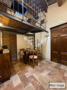 a kitchen with a table and a spiral staircase at PienzaLettings "Casa Gioia" in Pienza