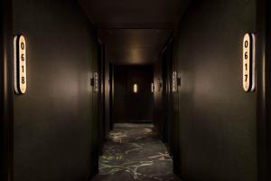 a hallway with black walls and a long hallway with lights at Moxy NYC East Village in New York