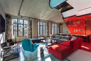 a living room with a red couch and blue chairs at Moxy NYC East Village in New York