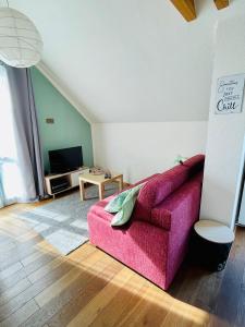 a living room with a pink couch and a table at Ferienwohnung „Klein aber fein“ in Urbar