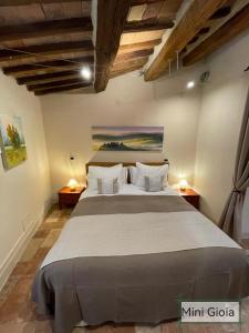 ein Schlafzimmer mit einem großen Bett in einem Zimmer in der Unterkunft PienzaLettings "Casa Gioia" in Pienza