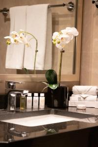 um balcão de casa de banho com um lavatório com flores em Elite Downtown Residences - Paradise View em Dubai