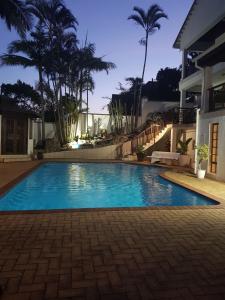 a swimming pool in front of a house at Ingwe Manor Guesthouse in Margate