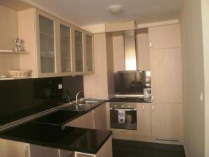a kitchen with white cabinets and black counter tops at Apart Hotel Apolonia Palace in Sinemorets