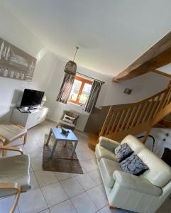 ein Wohnzimmer mit einem Sofa und einem Tisch in der Unterkunft La Grange du marais de Sailly-Bray in Noyelles-sur-Mer