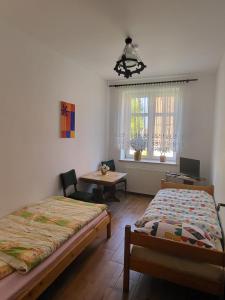 a bedroom with two beds and a table and a desk at Kwatery pod wieżą 