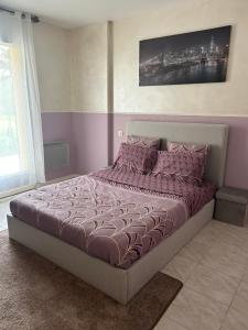 ein Schlafzimmer mit einem großen Bett mit violetter Bettwäsche in der Unterkunft La Palmeraie in Saint-Père