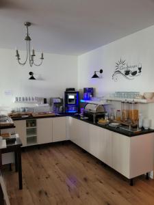a kitchen with white cabinets and a black counter top at Pension Am Ozeaneum in Stralsund