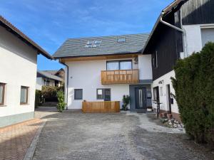 a white house with a black roof and a driveway at Bled Lake Apartment House in Bled