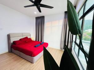 1 dormitorio con cama roja y ventilador de techo en Cozy Family Escape by StayCo - Pool, KTV, Outdoor Cinema & JACUZZI - Just 2 mins to Beach, en Batu Ferringhi