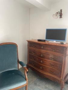 a desk with a chair and a computer on top of a dresser at La Ferme l'Etang in Vachères