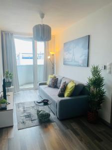 a living room with a couch and a large window at New apt in new building located begin of Petrzalka in Bratislava