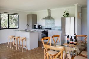 a kitchen with a glass table and some bottles of wine at Djilba Cottage at Windance in Yallingup