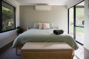 a bedroom with a large bed with a large window at Djilba Cottage at Windance in Yallingup