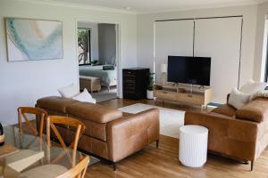 a living room with a couch and a flat screen tv at Djilba Cottage at Windance in Yallingup