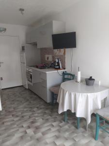 una cocina con mesa y una cocina con mesa y sillas en Jolie studio 2 étoiles proche de l'étang de thau, en Balaruc-les-Bains