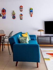 um sofá azul numa sala de estar com uma televisão em Central Caldas w/ AC & Fast Net nas Caldas da Rainha