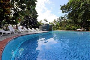 una gran piscina con sillas blancas y una piscina en La Baula Lodge, en Tortuguero