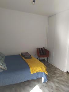 1 dormitorio con 1 cama con manta amarilla y silla en Jolie studio 2 étoiles proche de l'étang de thau, en Balaruc-les-Bains
