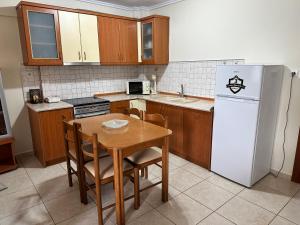 cocina con mesa y nevera blanca en Archontia Apartment, en Flogita