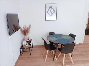 a dining room with a table and chairs at Appartement cosy dans une maison calme et parking gratuit avec borne in Illkirch-Graffenstaden +8 photos