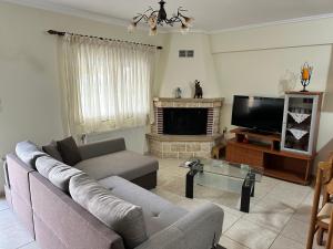 a living room with a couch and a tv at Archontia Apartment in Flogita