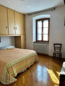 - une chambre avec un lit, une fenêtre et une chaise dans l'établissement Villa Elisabetta, à Chiusi della Verna
