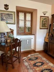 une chambre avec un bureau, une table et un radiateur dans l'établissement Villa Elisabetta, à Chiusi della Verna