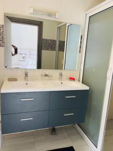 a bathroom with two sinks and a large mirror at Terranga et douceur aux almadies in Dakar