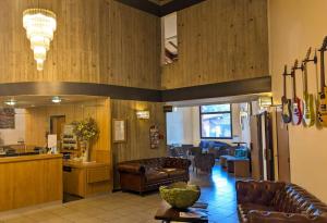 - un hall avec des meubles en cuir et une salle d'attente dans l'établissement KYRIAD LYON EST - Genas Eurexpo, à Genas