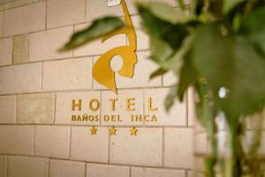 znak dla hotelu na ścianie w obiekcie Baños del Inca Premium Hotel w mieście Los Baños del Inca