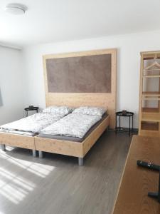 1 dormitorio con 1 cama con cabecero de madera en Alte Innbrücke, en Schärding