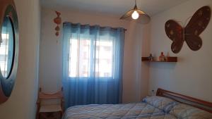 sypialnia z łóżkiem i oknem motyla w obiekcie Bonito apartamento en Marina D'or [1ra línea de playa] w mieście Oropesa del Mar +9 zdjęć