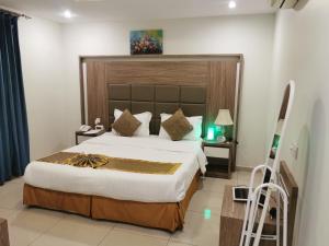 a bedroom with a large bed with a large headboard at فندق سمأ الرفاع 2 in Al Khobar