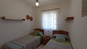 dwa łóżka w małym pokoju z oknem w obiekcie Bonito apartamento en Marina D'or [1ra línea de playa] w mieście Oropesa del Mar