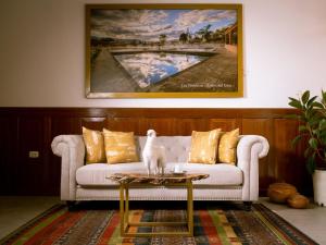 een woonkamer met een witte bank en een tafel bij Baños del Inca Premium Hotel in Los Baños del Inca