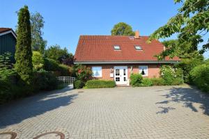 una casa in mattoni con tetto rosso e vialetto di Haus Antje-Kellenhusen Whg2 a Kellenhusen