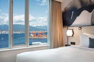 pokój hotelowy z łóżkiem i dużym oknem w obiekcie Delta Hotels by Marriott Vancouver Downtown Suites w mieście Vancouver